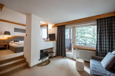 a living room with a couch and a bed and a window at Sporthotel Teresa in Badia