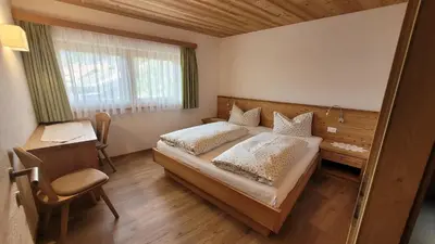a bedroom with a bed and a desk and a chair at Apartments Ingrid in La Valle