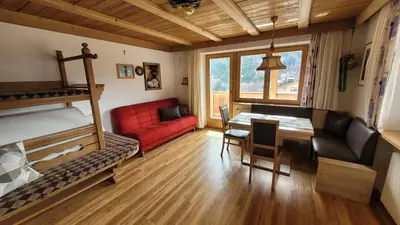 a living room with a bunk bed and a dining room at Apartments Ingrid in La Valle