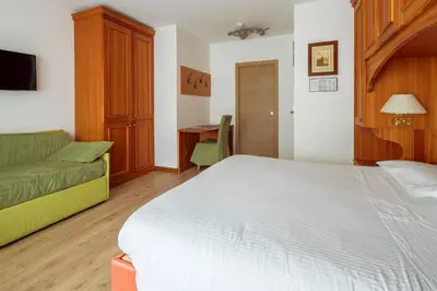 a hotel room with a bed and a desk at Barisetti Sport Hotel in Cortina dʼAmpezzo