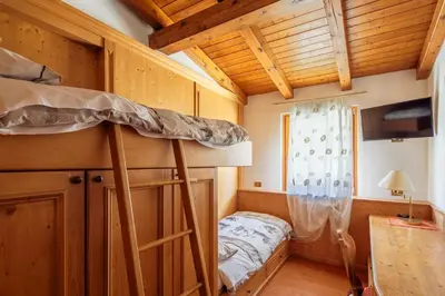 a bedroom with two bunk beds in a cabin at Barisetti Sport Hotel in Cortina dʼAmpezzo
