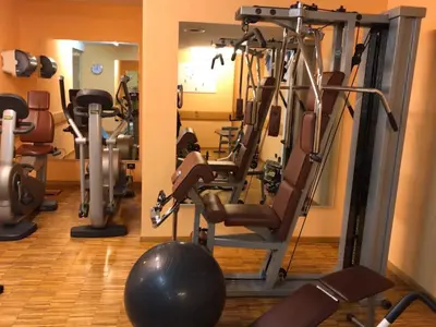 a gym with several tread machines and a ball at Hotel Medil in Campitello di Fassa