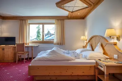 a bedroom with a bed and a desk and a television at Hotel Bellavista in Alpe di Siusi