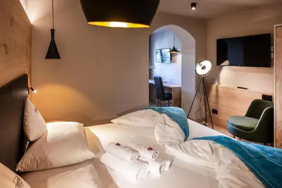 a bedroom with a bed with two stuffed animals on it at Hotel Bellavista in Alpe di Siusi