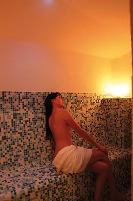 a man sitting on a couch in a room with tiles at Hotel Bellavista in Alpe di Siusi