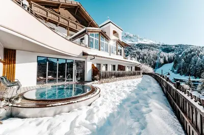 a house with a swimming pool in the snow at Hotel Obereggen in Obereggen