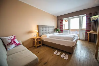 a hotel room with a bed and a couch at Hotel Obereggen in Obereggen