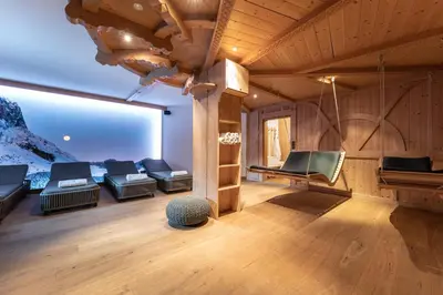 a living room with couches and a large window at Hotel Obereggen in Obereggen