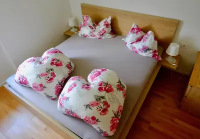 a bed with four pillows in the shape of hearts at Agriturismo Reinhof in San Felice