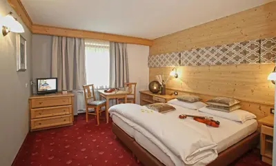a hotel room with a large bed and a desk at B&B Tamarindo in La Villa