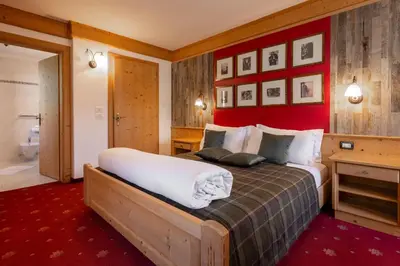 a bedroom with a large bed and a red wall at B&B Tamarindo in La Villa