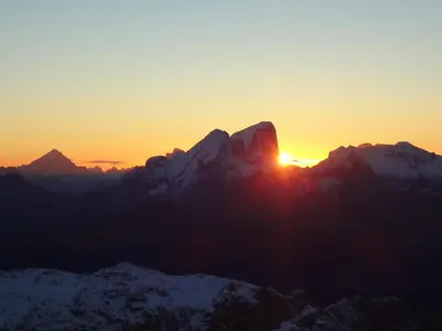 a sunset over a mountain range with snow covered mountains at Hotel Al Viel B&B in Canazei
