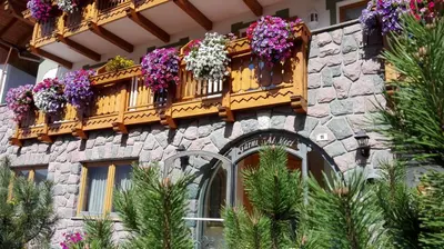 a building with a bunch of flowers on a balcony at Hotel Al Viel B&B in Canazei