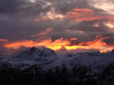 a sunset over a snow covered mountain range at Hotel Al Viel B&B in Canazei