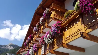 a building with flowers on the side of it at Hotel Al Viel B&B in Canazei