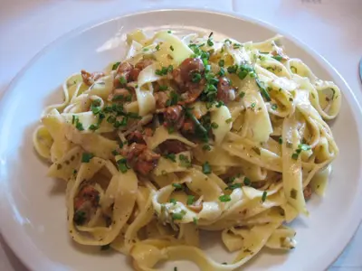 a white plate of pasta with meat and sauce at Pension Höggerhof in Nova Ponente