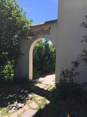 an archway over a road with a sign that reads institution at Pension Höggerhof in Nova Ponente