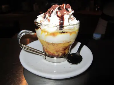 a cup of ice cream with whipped cream and a spoon at Hotel Bucaneve in Moena