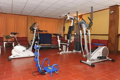 a gym with three exercise bikes in a room at Hotel Bucaneve in Moena