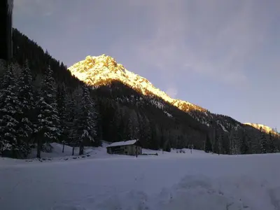 a snow covered mountain with a cabin in the foreground at Hotel Bucaneve in Moena
