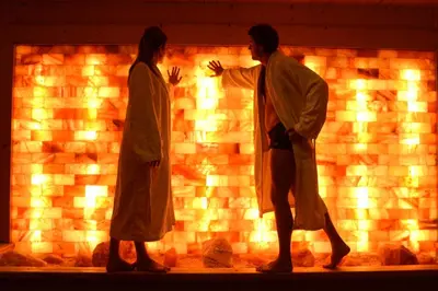 two people are standing in front of a brick wall at Rio Stava Family Resort & Spa in Tesero