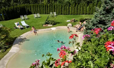 a group of people in a swimming pool in a yard at Rio Stava Family Resort & Spa in Tesero