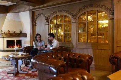 a man and a woman and child sitting in a living room at Rio Stava Family Resort & Spa in Tesero