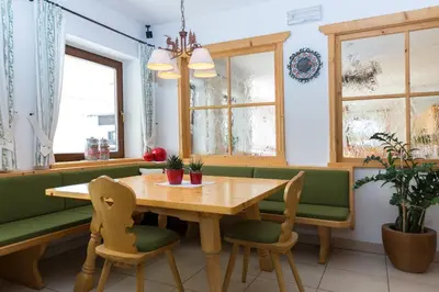 a dining room with a wooden table and chairs at Hotel Falken in Falzes