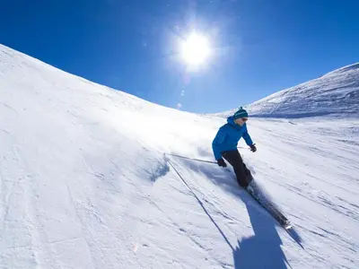 a person is skiing down a snow covered slope at Hotel Falken in Falzes