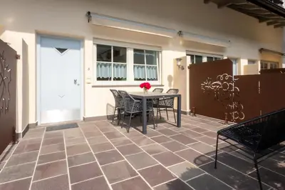 a patio with a table and chairs in front of a building at Residence Hof am Keller in Montagna