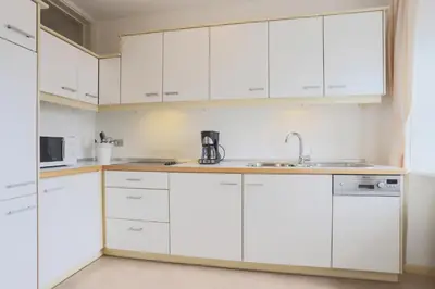 a kitchen with white cabinets and a sink at Residence Hof am Keller in Montagna
