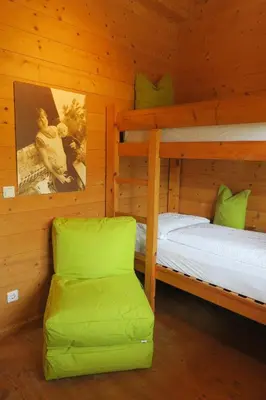 a bedroom with two bunk beds and a chair at Winklerhof in Parcines