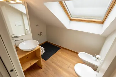 a bathroom with two sinks and a skylight at Agalma in Brunico