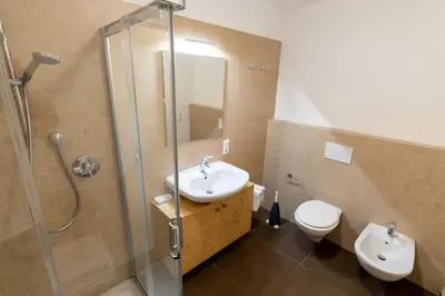 a bathroom with a sink and a shower and a toilet at Agalma in Brunico