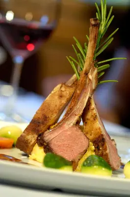 a piece of meat on a plate with a glass of wine at Hotel Burgfrieden in Gais