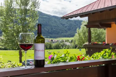 a bottle of wine and a glass on a table at Hotel Burgfrieden in Gais