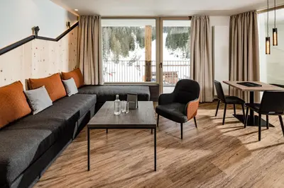 a living room with a couch and a table at Sporthotel Obereggen in Obereggen