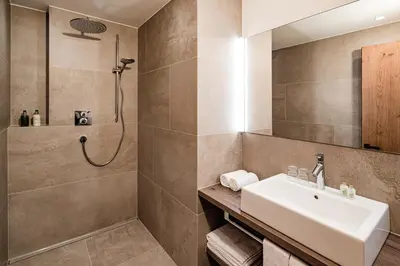 a bathroom with a sink and a shower at Sporthotel Obereggen in Obereggen