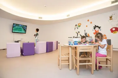 two children sitting at a table in a room at Hotel Garden in Moena