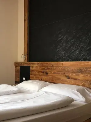 two beds in a bedroom with a chalkboard on the wall at Park Hotel Avisio in Soraga