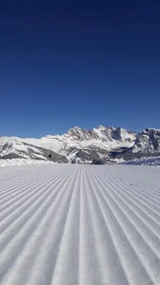 a field of snow with mountains in the background at Garni Rubens B&B in Selva di Val Gardena