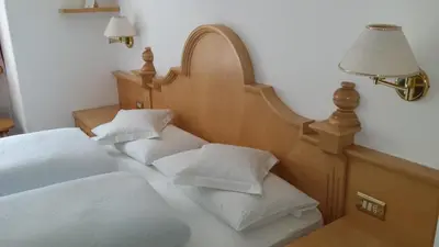 a bedroom with two beds with white pillows at Garni Rubens B&B in Selva di Val Gardena