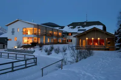 a large house in the snow at night at Residence Tolderhof - Olang in Valdaora