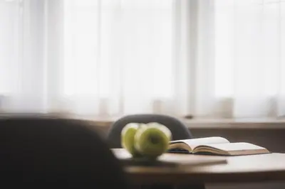 a desk with an open book and an apple on it at Residence Chiavi D'Oro - Goldener Schlüssel in Bressanone