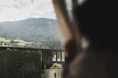 a person looking out a window at a mountain at Residence Chiavi D'Oro - Goldener Schlüssel in Bressanone