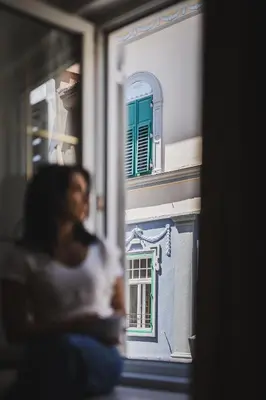 a woman is looking out of a window at a building at Residence Chiavi D'Oro - Goldener Schlüssel in Bressanone