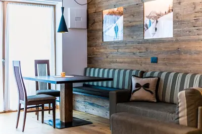 a living room with a table and a couch at Garni Hotel Rosengarten B&B in Selva di Val Gardena