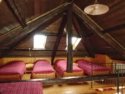 a room with four beds in a attic at Baita Casera Caviazza in Falcade