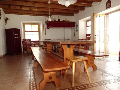 a dining room with a wooden table and benches at Baita Casera Caviazza in Falcade