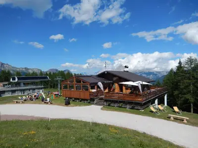 a train station with people sitting in the grass at Baita Casera Caviazza in Falcade